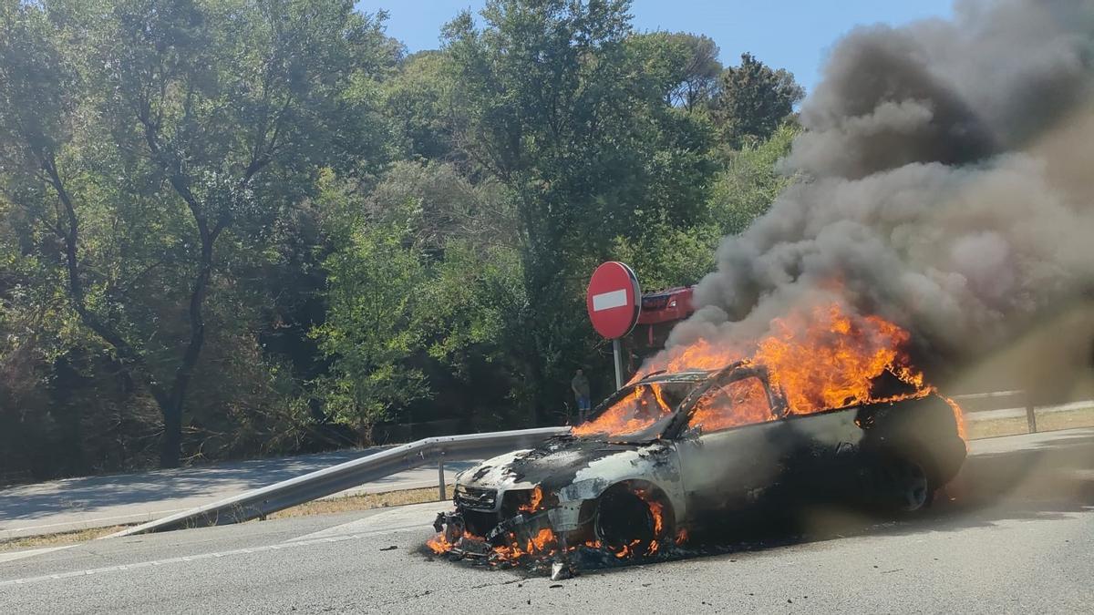 Coche incendiado en la retención provocada por el accidente de un camión en Hostalric