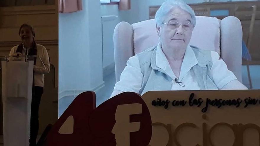 La hermana Inmaculada Sancho se dirige al público; en el vídeo, Lourdes Carballo, directora del Albergue Covadonga.