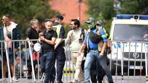 El manifestante Salwan Momika escoltado por la policía antes de empezar el acto de quema del Corán