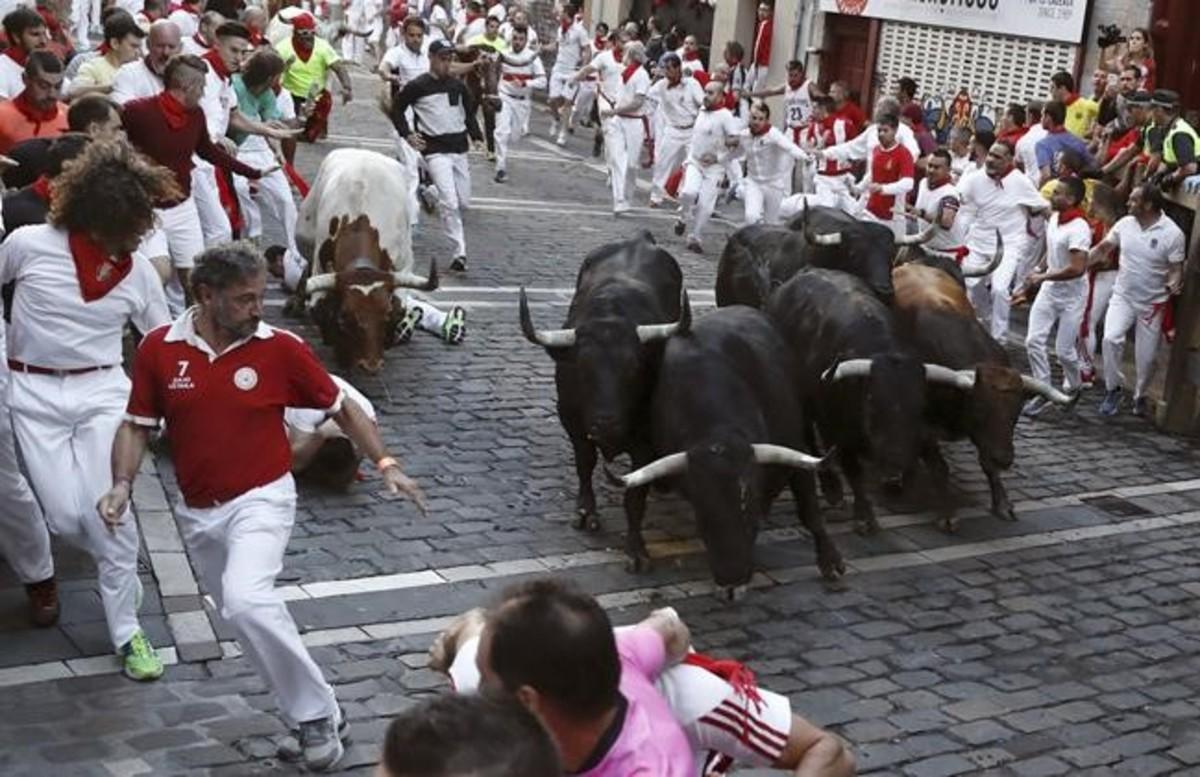 Los toros de la ganaderia madrilena de Victoriano del Rio llegan a la curva de Mercaderes de Pamplona  durante el sexto encierro de San Fermín 2017 