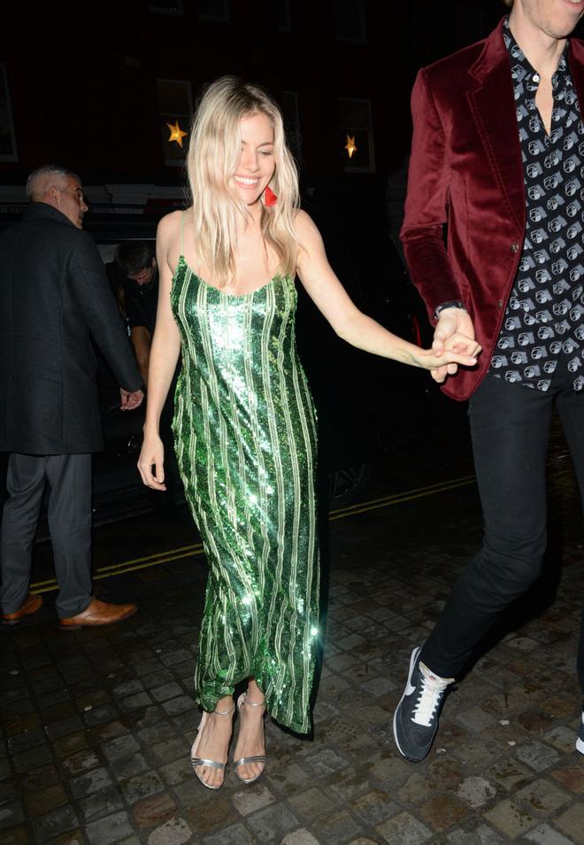Sienna Miller con un vestido de fiesta de lentejuelas verde y rayas verticales de la firma británica Galvan