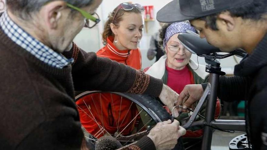 Un usuario de Bicilab enseña a los asistentes al taller cómo ajustar los frenos.