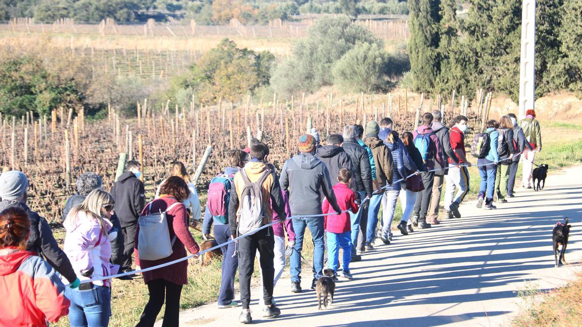 Veïns d&#039;Espolla que han participat en la caminada pujant al turó amb la vara que simula una pala de l&#039;aerogenerador