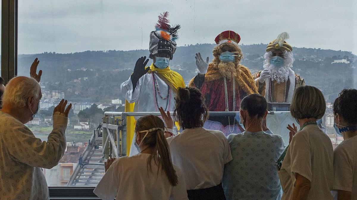 Los Reyes Magos saludan a pacientes y personal sanitario desde el elevador de los Bomberos, en el edificio nuevo del CHUO. |   // BRAIS LORENZO