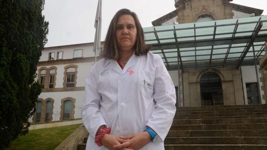 Esther Martínez, con su bata de voluntaria, ante el Hospital Provincial de Pontevedra. // Rafa Vázquez