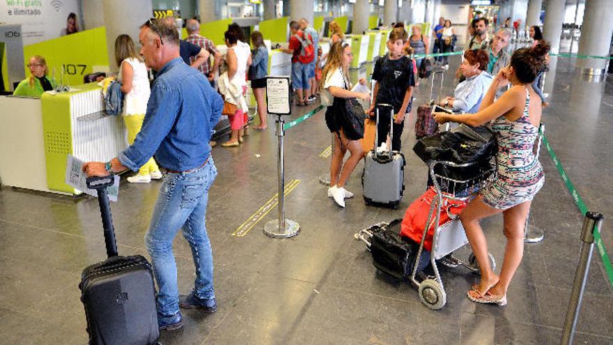 Varios pasajeros hacen cola en la zona de facturación del aeropuerto de Gran Canaria el pasado jueves.