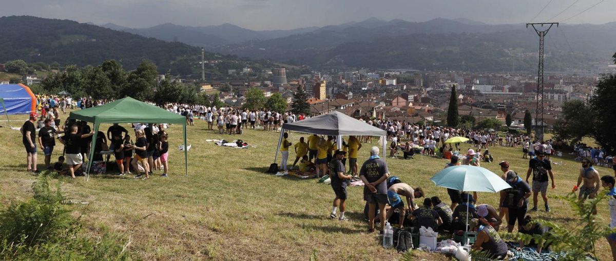 Arriba, vista del «prau» de Castandiello en la jira. Abajo a la izquierda, varios romeros refrescándose con pistolas de agua. A la derecha, la actuación en la madrugada del lunes del grupo «Assia». | FERNANDO RODRÍGUEZ / SOCIEDAD SAN PEDRO