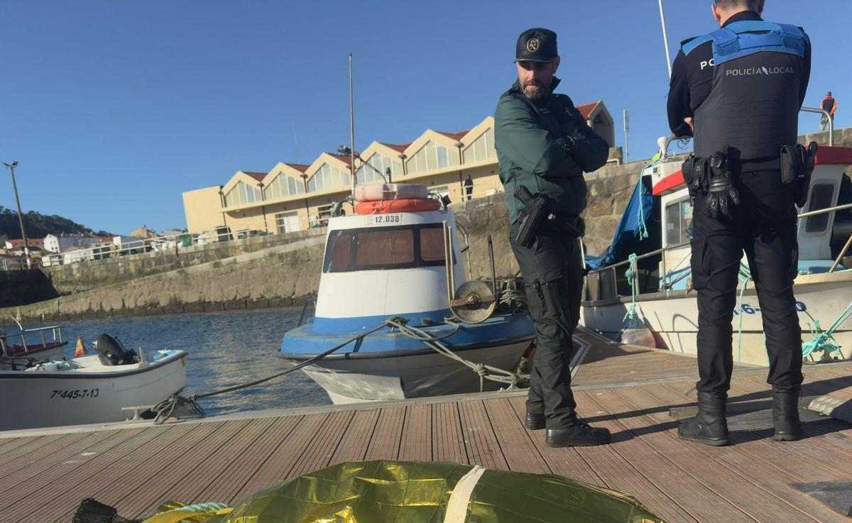 Dos agentes en un pantalán del muelle de O Porto do Son, al que fue trasladado el cadáver.