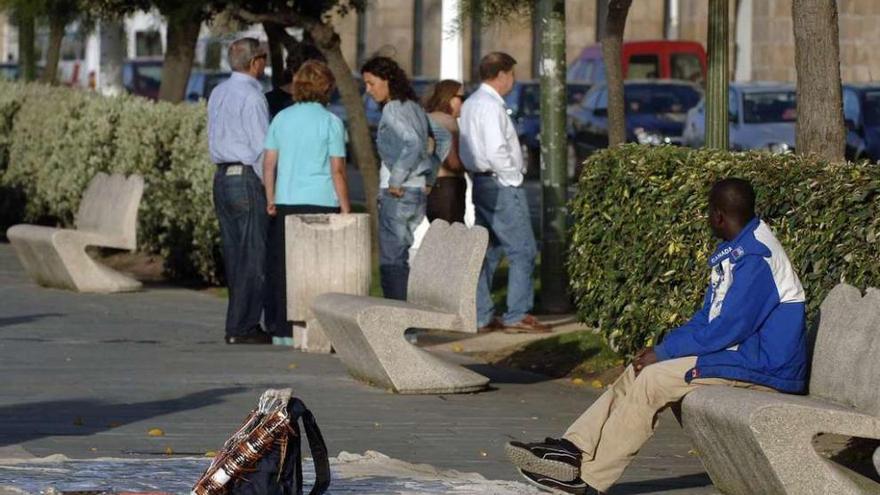 Imagen de un inmigrante en un puesto de venta ambulante en el paseo marítimo.