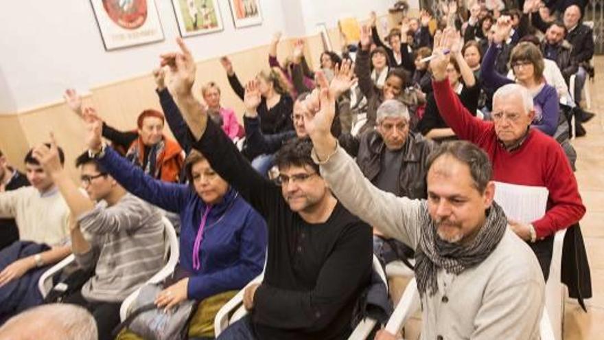 Los ediles Pavón y Domínguez alzan la mano anoche durante la asamblea de Guanyar.