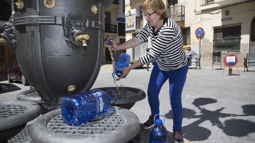 Una vecina llenando garrafas de agua. Foto: Carme Ripollés