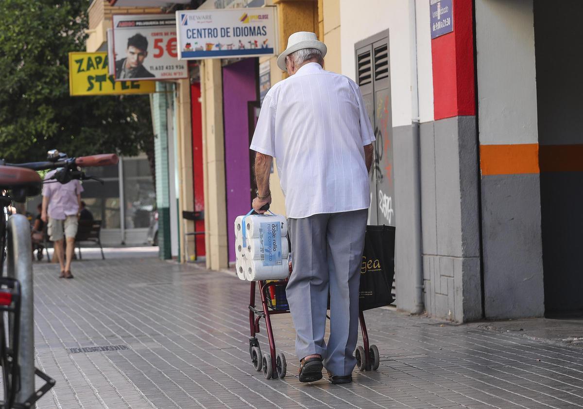 Un hombre arrastra la compra, en una imagen captada en València.