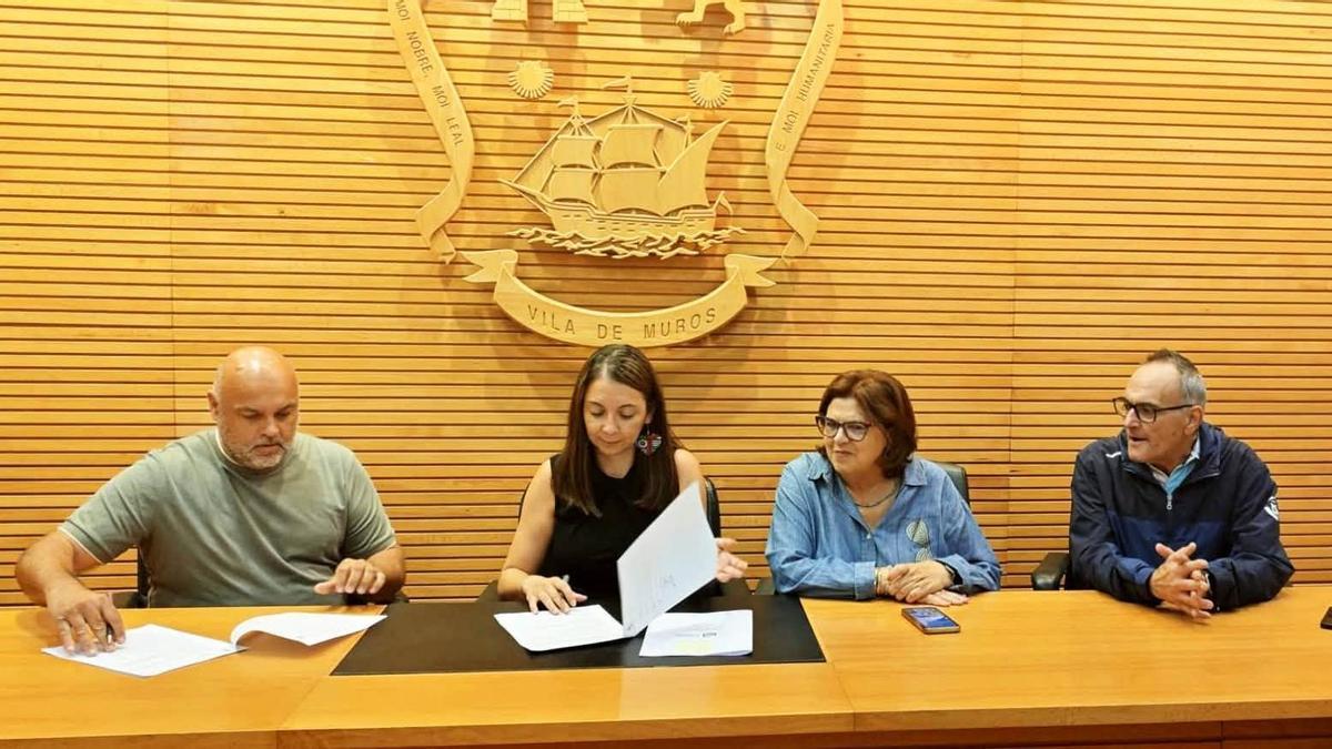 María Lago, segunda pola esquerda, e Caridad González, asinando os convenios cos organizadores do Gran Prix das Carrilanas e do Festival Castelo Rock.