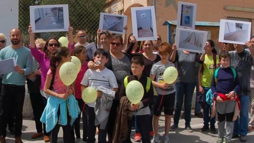 Padres y escolares de La Cañada del Fenollar protestan con globos y fotografías ampliadas de las aulas prefabricadas anegadas.