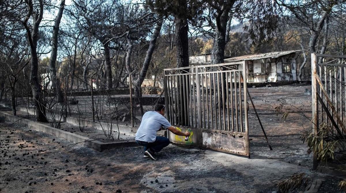 zentauroepp44449847 a expert marks with paint a burnt house following a wildfire180726181033