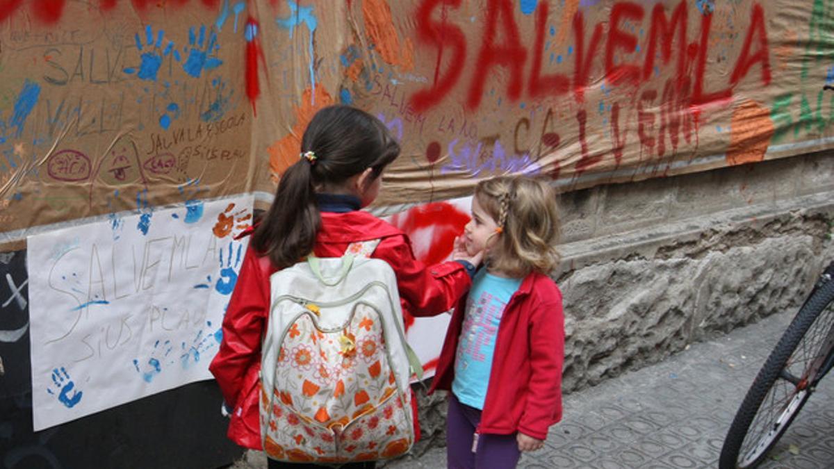 Dos niñas junto al cartel en defensa de la Vil·la Urània, hoy.