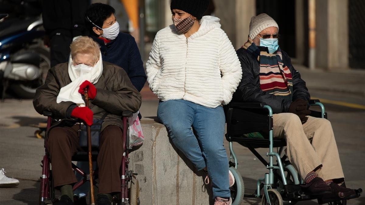 GRAFCAT5715 BARCELONA  9 12  2020 - Dos ciudadanos acompanados por sus cuidadoras toman el sol en la plaza de la Catedral de Barcelona tras mejorar ligeramente la situacion epidemiologica en Cataluna y la velocidad de contagio (Rt) de la Covid-19  manteniendose por debajo de 1  aunque la evolucion de la misma sigue siendo sin embargo comprometida a pocas semanas de las fiestas navidenas  EFE Enric Fontcuberta