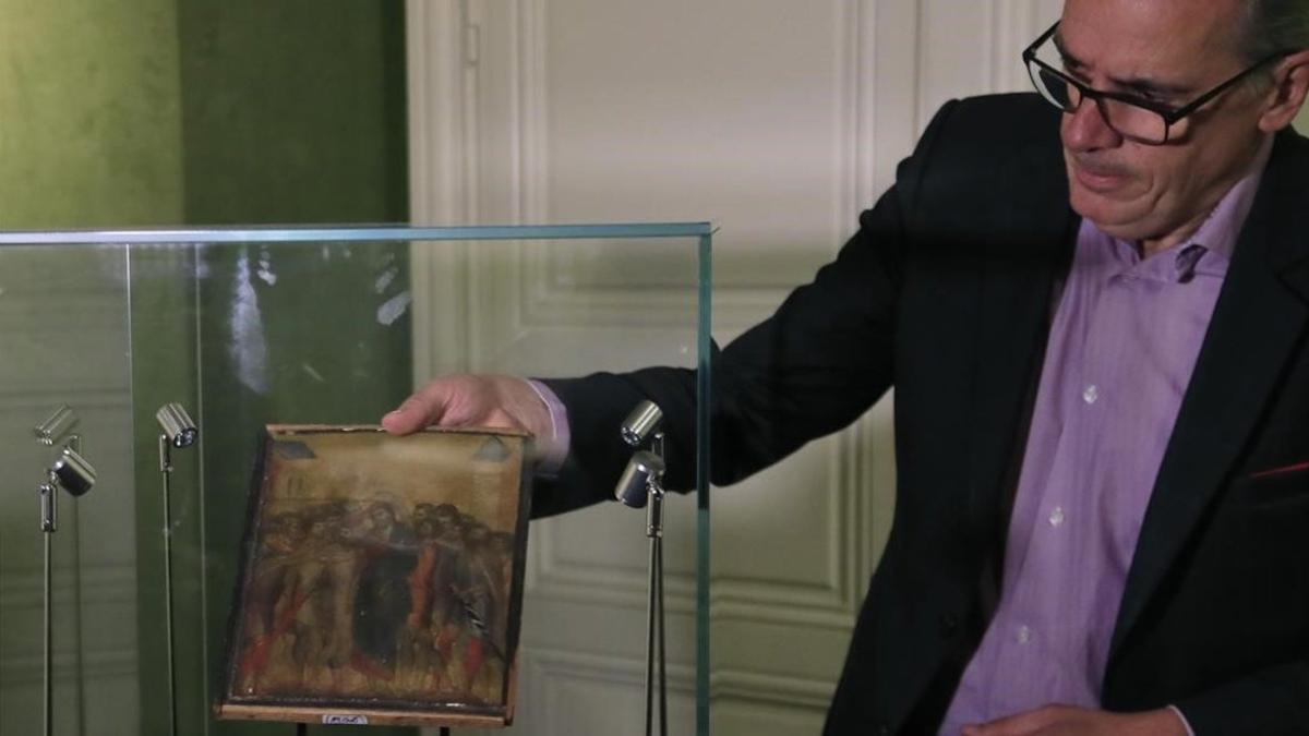 Un experto muestra el Cimabue subastado en París.