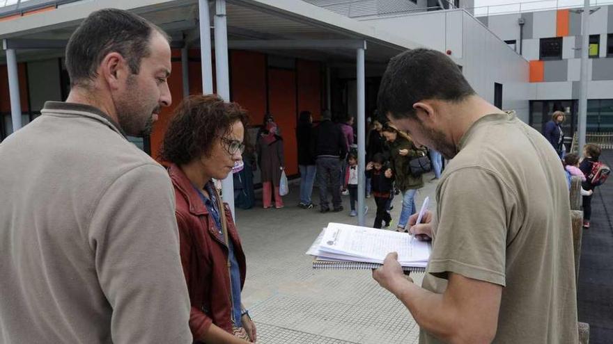 Un grupo de padres firma, ayer, en los documentos que serán remitidos a la Xunta. // Bernabé/Javier Lalín