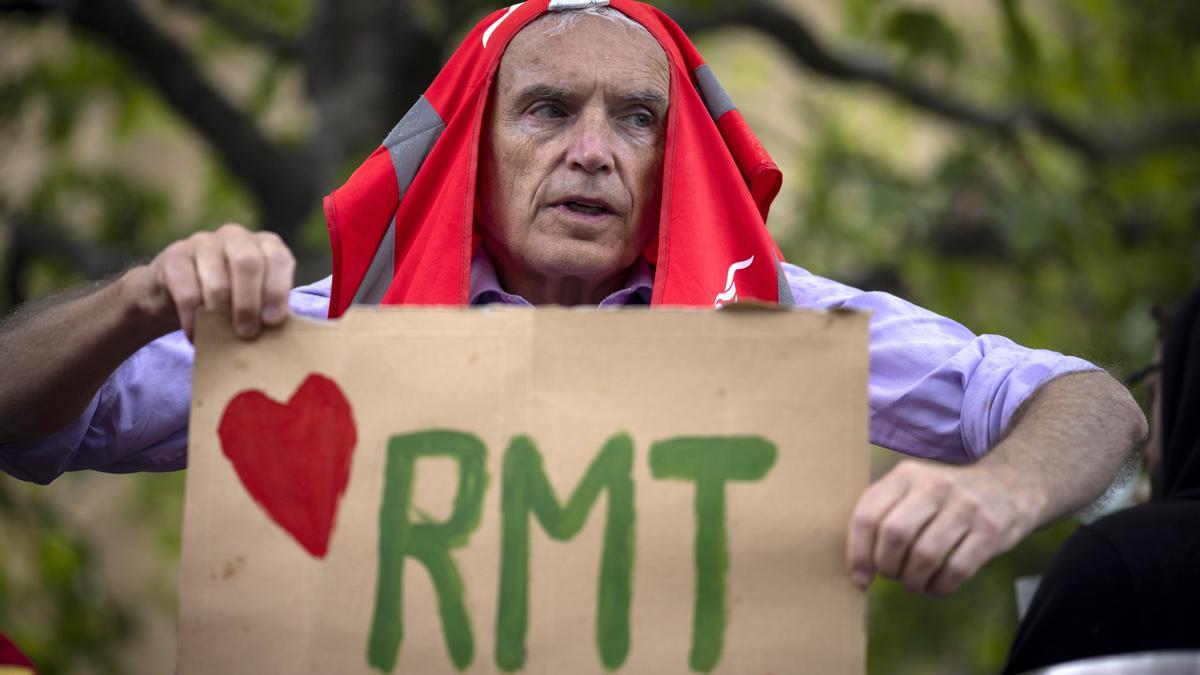 Un manifestante sostiene una pancarta mientras los miembros del sindicato National Union of Rail, Maritime and Transport Workers (RMT)