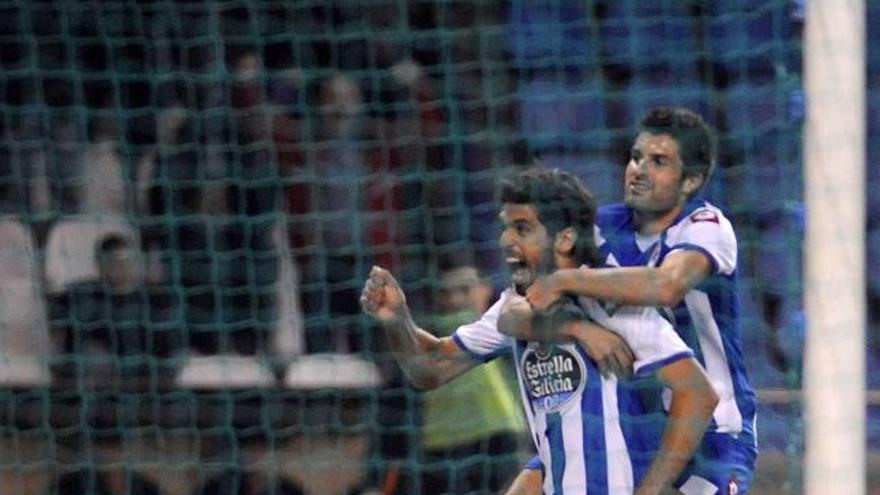 Lassad, del que está colgado Saúl, celebra su gol ante la grada de fondo de Maratón. / eduardo vicente