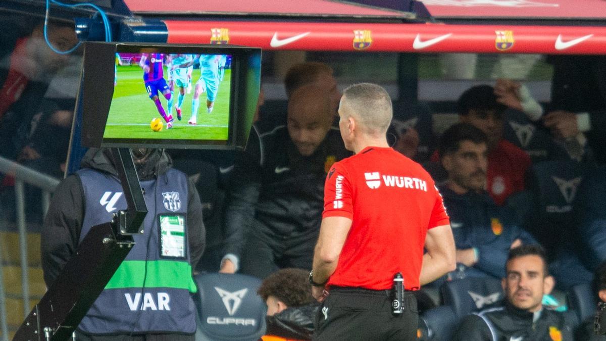 Iglesias Villanueva, el colegiado del Barça-Mallorca, observa en la pantalla el golpe de Copete a Raphinha, que provocó el penalti fallado por Gündogan.