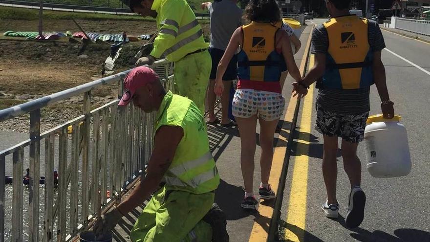 Unos peatones, el pasado verano, ocupando la carretera por la estrechez de la acera del puente Emilio Llamedo de Arriondas.