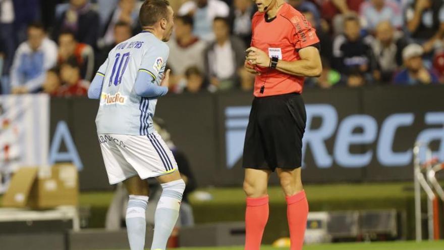 El colegiado muestra la seguna amarilla a Aspas en el partido ante el Real Madrid disputado en Balaídos. / R. Grobas