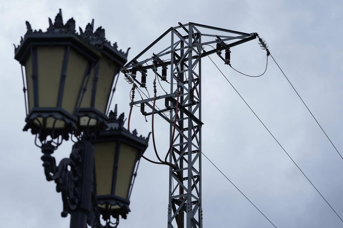 Una farola junto a una torreta de la luz en Oviedo. EFE/Paco Paredes