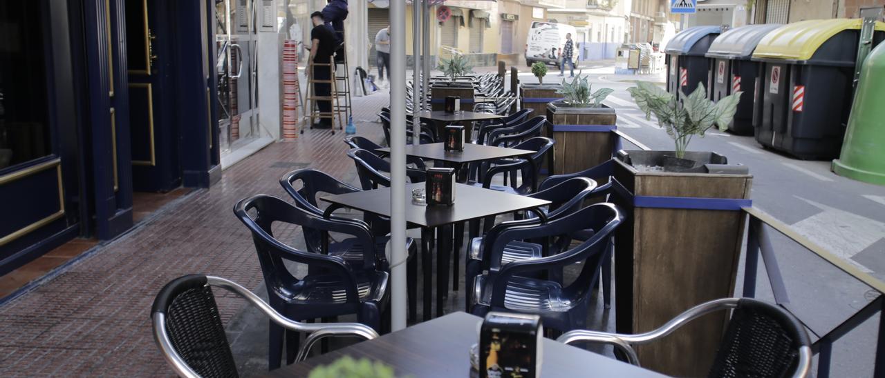 Mesas y sillas en una terraza en el corazón de Santa Pola, junto a la calle Muelle