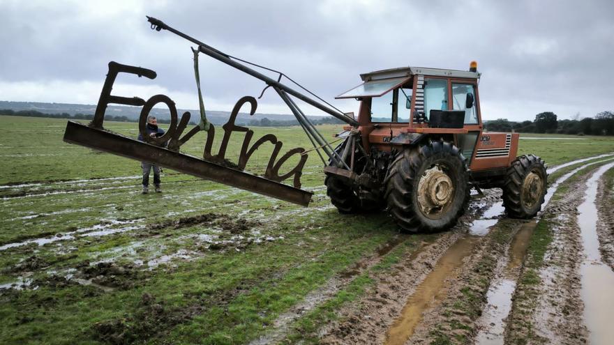 Un tractor contratado por el Ayuntamiento de Fonfría recoge el cartel robado, abandonado en el paraje de la Urrieta. | P. O.