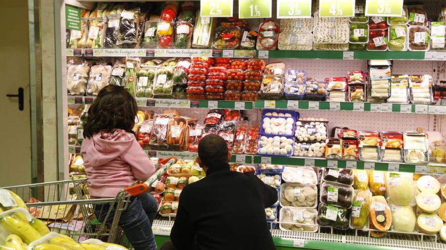 Un padre y su hija comprando en el supermercado.