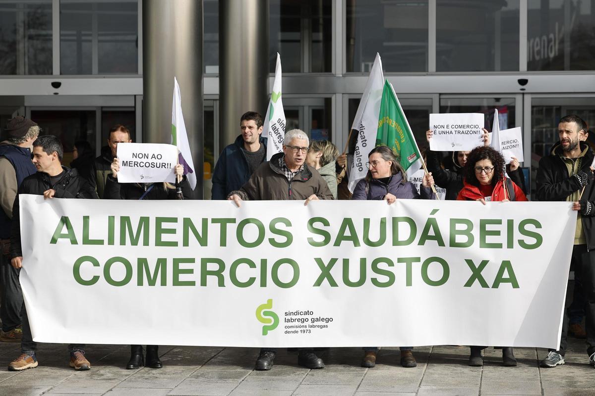 Una veintena de agricultores convocados por el Sindicato Labrego Galego, protestan por el tratado de Mercosur, ante un centro comercial este jueves en Santiago de Compostela.