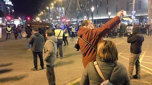 Un turista se hace una ’selfie’ al paso del ataud policial, en plaza de Catalunya.