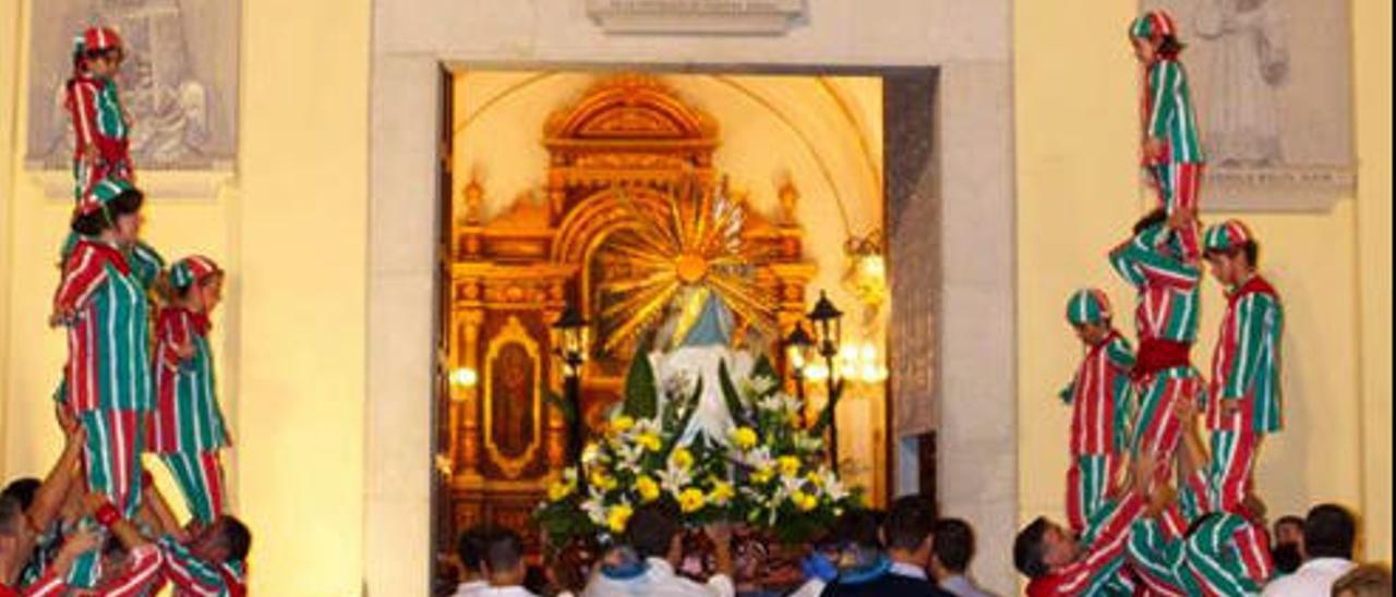 La imagen entra en la iglesia flanqueada por la «Muixeranga».