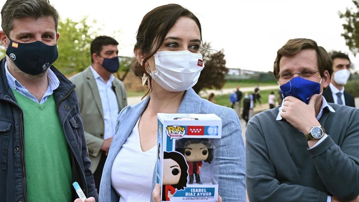 MADRID  29 03 2021 - La presidenta de la Comunidad de Madrid y candidata a la reeleccion  Isabel Diaz Ayuso (c)  posa con su Funko Pop junto al portavoz nacional del PP y alcalde de Madrid  Jose Luis Martinez-Almeida (d)  mientras recorren el Parque Juan Carlos I para visitar las mesas informativas del voto por correo  este lunes en Madrid  EFE  Fernando Villar