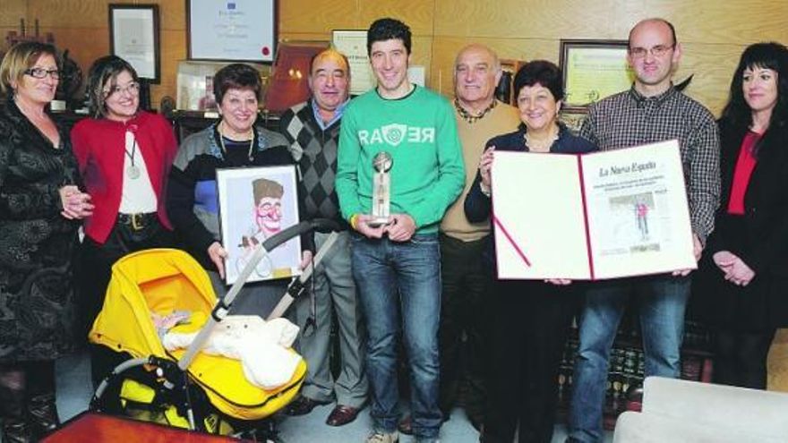 De izquierda a derecha, Amaya García, Ana Rubiera, Loli Vigil, José Luis Rubiera, Chechu Rubiera, Alfredo y Lucy Vigil, Vicente Fernández y Laura Pozuelo, con el bebé Noah Rubiera en la silla, ayer, en LA NUEVA ESPAÑA, con los galardones recibidos por el deportista.