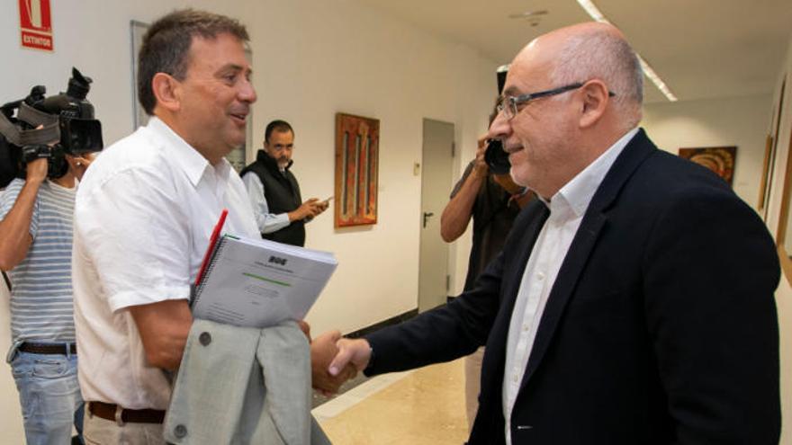 Luis Ibarra y Antonio Morales se saludan durante las negociaciones para formar un pacto en el Cabildo.