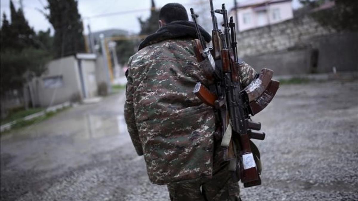 Un soldado de las fuerzas de antodefensa de Nagorno-Karabaj cargado de fusiles antes de firmarse el acuerdo de alto el fuego.