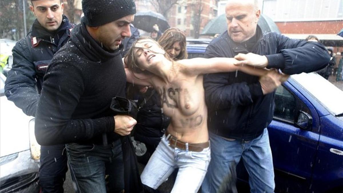 La policía italiana detiene a una activista de Femen ante el colegio electoral de Silvio Berlusconi en Milán, durante las elecciones del pasado mes de febrero.