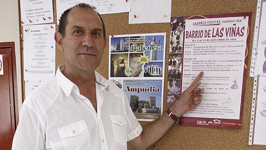 El presidente de la asociación vecinal muestra el cartel de fiestas.