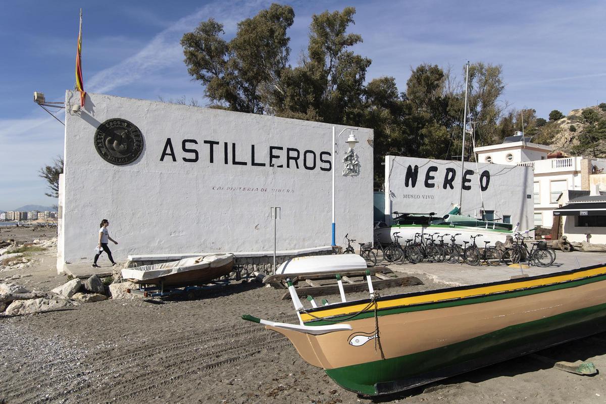 Una persona camina frente a la entrada principal de los Astilleros Nereo del barrio de Pedregalejo