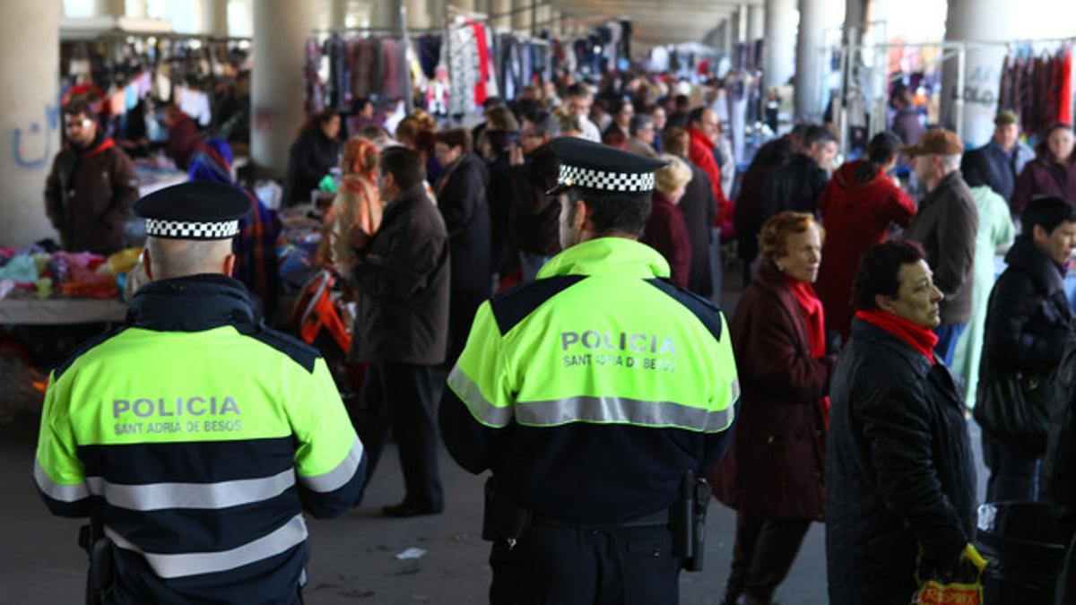 Los agentes de la policía local de Badalona y Sant Adria vigilan la venta ambulante en un mercado.