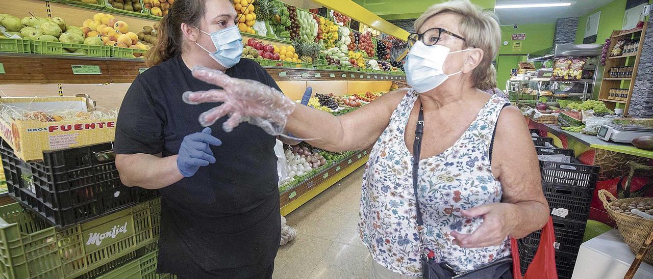 Dos mujeres discuten en una frutería las razones que justifican que se adopten estas decisiones sanitarias.