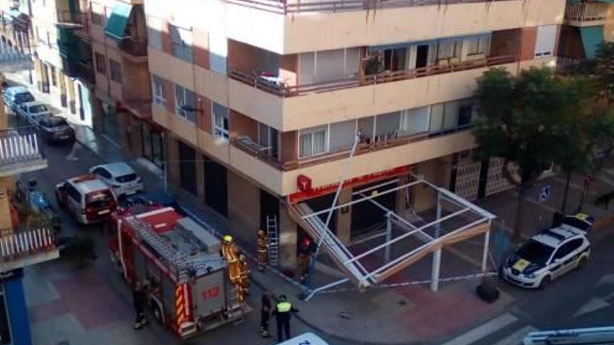 Los bomberos retiran el poste afectado por el accidente de tráfico.