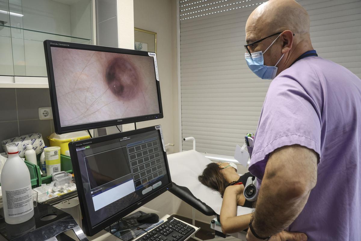 Un dermatólogo pasa consulta a una paciente en un hospital valenciano.
