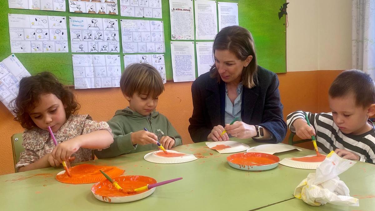 Lourdes García con tres niños en el colegio Buenavista II.