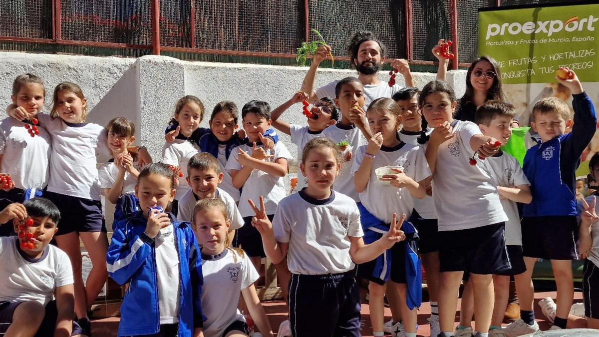 Alumnos madrileños con algunos de los productos murcianos incluidos en su dieta escolar.