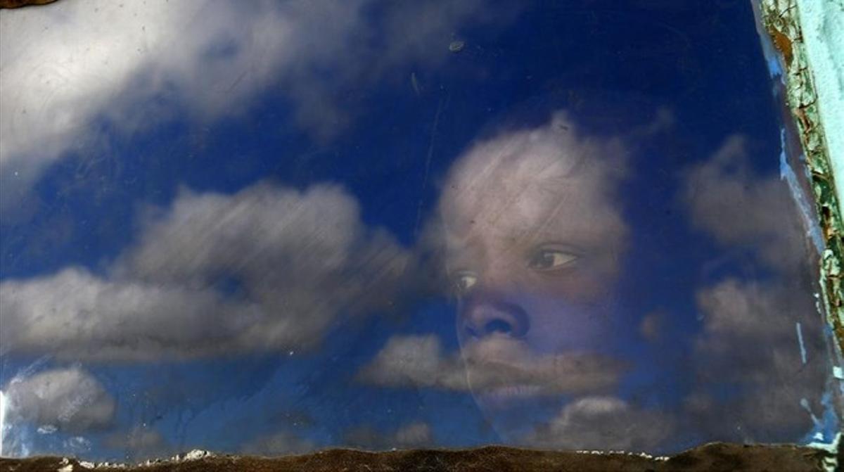 Un niño observa el cortejo fúnebre.