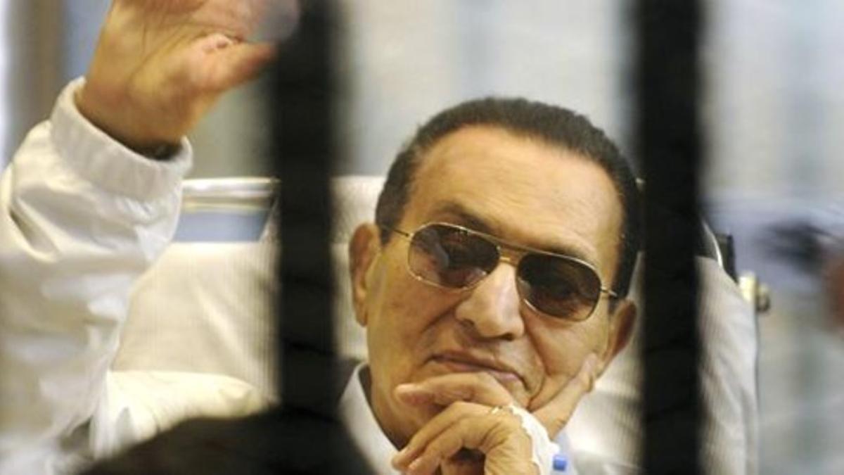 Mubarak saluda a sus seguidores entre rejas durante una vista judicial, el pasado 13 de abril.